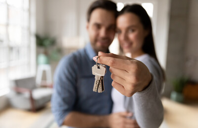 Paar mit Schlüsseln nach Immobilienkauf