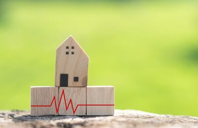 Ein Hausmodell aus Holz steht auf Holzblöcken