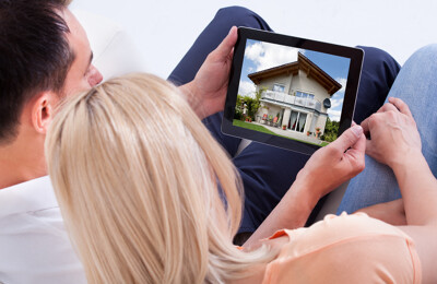 Paar betrachtet Bild von Haus auf Tablet