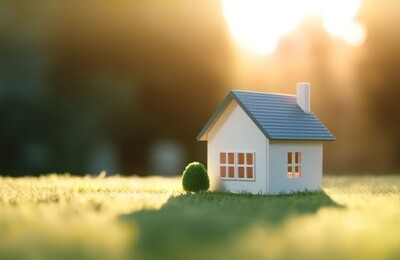 Ein Modellhaus steht auf einer grünen Wiese