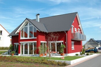 Ein freistehendes Einfamilienhaus mit rotem Putz