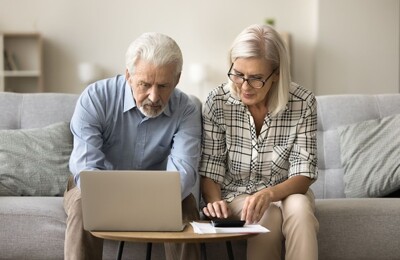 Immobilieneigentümer-Ehepaar arbeitet am Laptop