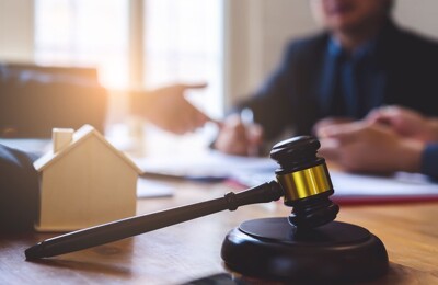 Ein Auktionshammer und ein Hausmodell aus Holz