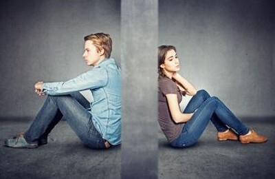 Junges Paar in Scheidung sitzt mit dem Rücken zueinander
