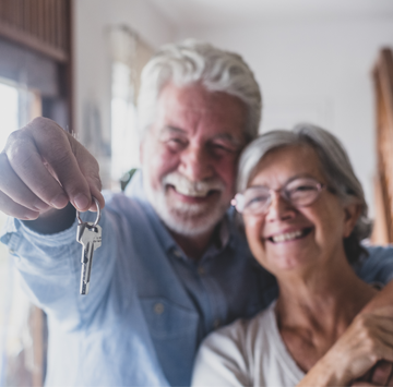 Glückliches älteres Ehepaar mit Hausschlüssel