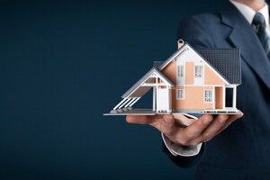 Mann hält Modellhaus in der Hand