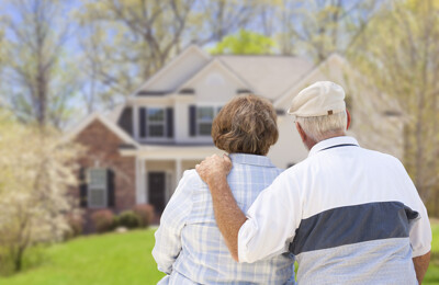 Älteres Ehepaar vor Haus