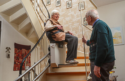 Seniorin im Treppenlift