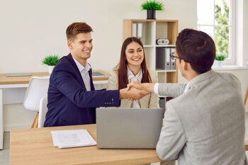 Handschlag zwischen Paar und Makler