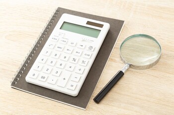 Lupe neben Taschenrechner