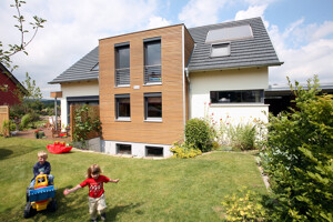 Einfamilienhaus mit spielenden Kindern im Garten