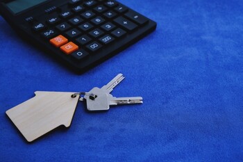 Ein Hausschlüssel liegt neben einem Taschenrechner
