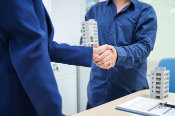 Ein Immobilienmakler und sein Kunde geben sich die Hand