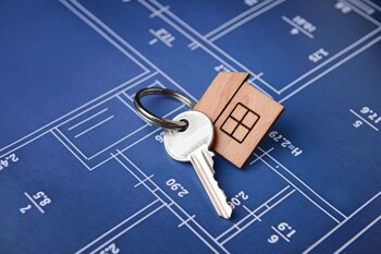 Ein Hausschlüssel liegt auf einem Grundrissplan