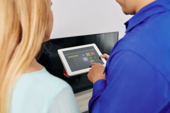 Eine Frau bedient ihr Smart Home mit einem Tablet