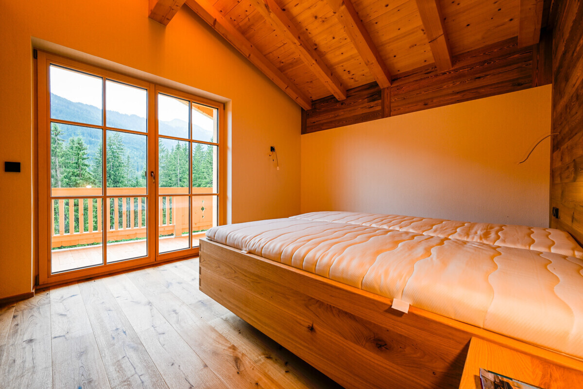 Schlafzimmer-Alm-Chalet-Aussicht-auf-die-Wiesen-und-Wälder-Hopfgarten-im-Brixental