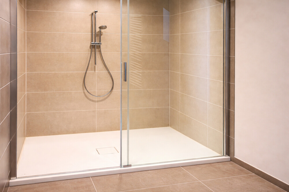 Moderne Dusche mit klarer Glaswand in Duschbad