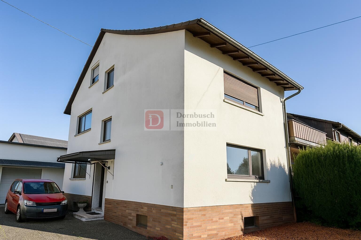 Hausansicht mit Eingangsbereich und Stellplatz