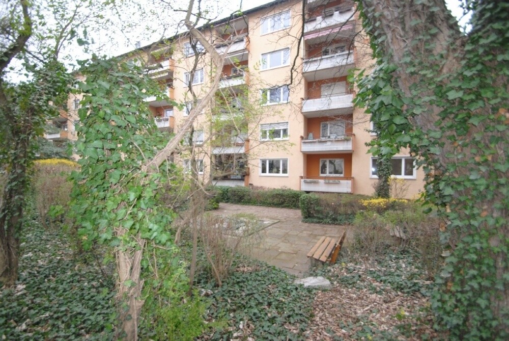 Haus umgeben von altem Baumbestand und Bachlauf