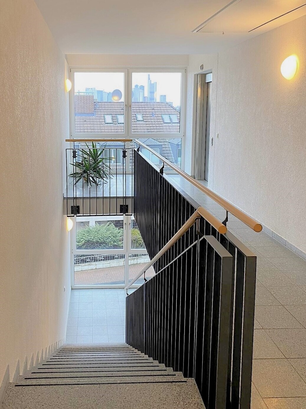 Freundliches Treppenhaus mit großflächigen Fensterfronten