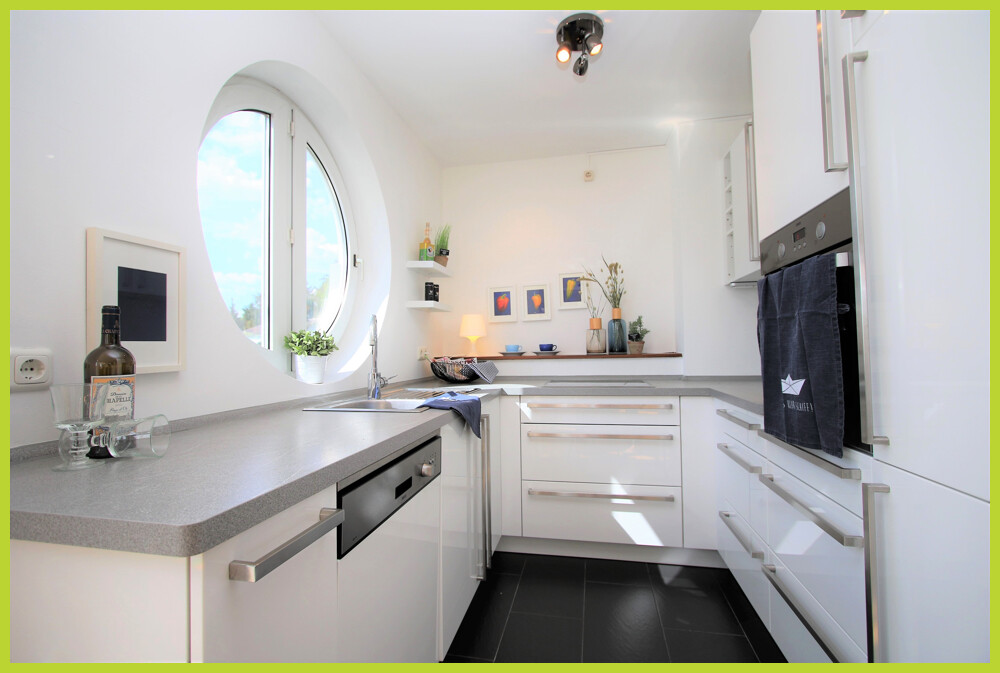 Küche mit Einbauküche und Rundfenster