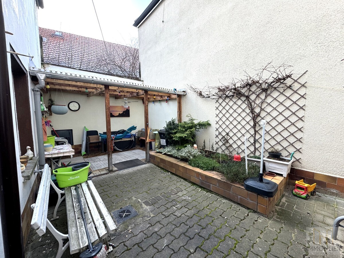 Innenhof mit Terrasse, Hochbeet und rankendem Wein