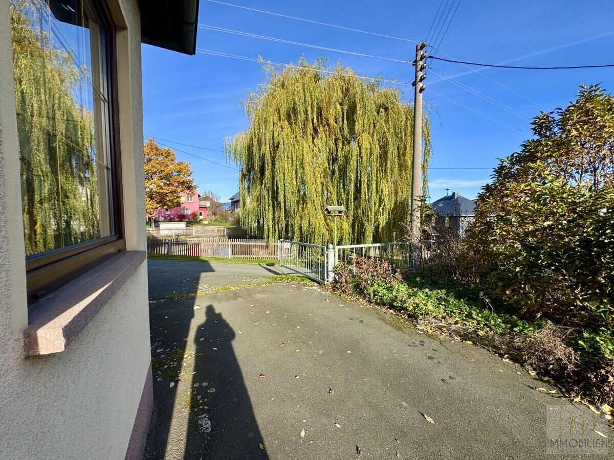Einfahrt mit Blick auf Löschteich vor dem Haus
