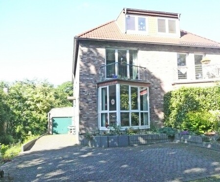 Frontansicht mit Glaserker im EG, Balkon im OG, 2 Stellplätzen und 1 Garage