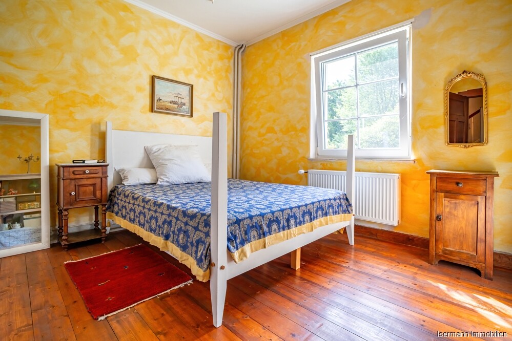 Das Schlafzimmer wirkt dank des Holzbodens und der Sprossenfenster sehr gemütlich.