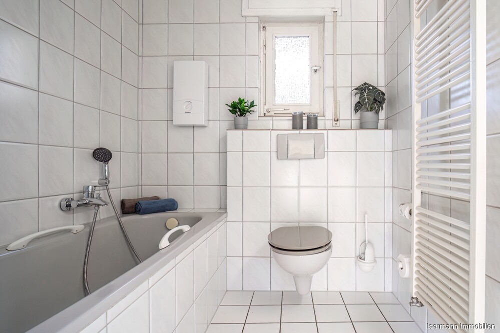 Weiße Fliesen in Kombination mit hellgrauer Keramik schaffen ein harmonisches Gesamtbild.