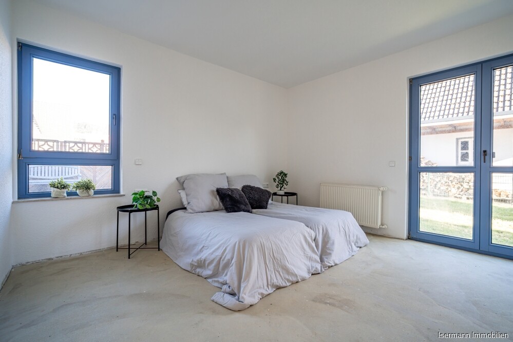 Das Schlafzimmer im Erdgeschoss wird von zwei Seiten belichtet.