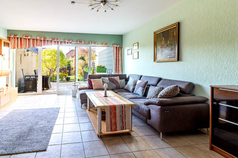 Helles und einladendes Wohnzimmer mit direktem Zugang zur Terrasse – der perfekte Ort für entspannte Stunden.