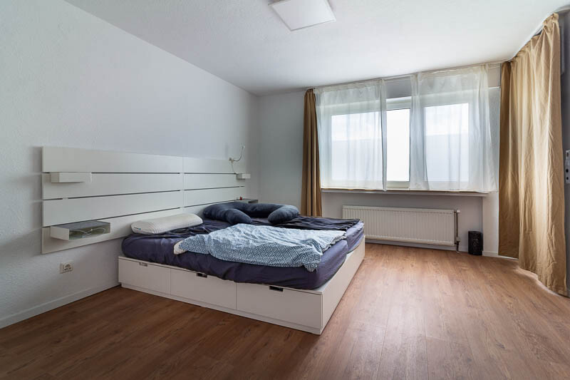 Ruhiges Schlafzimmer mit modernisierten Details und Balkonzugang.