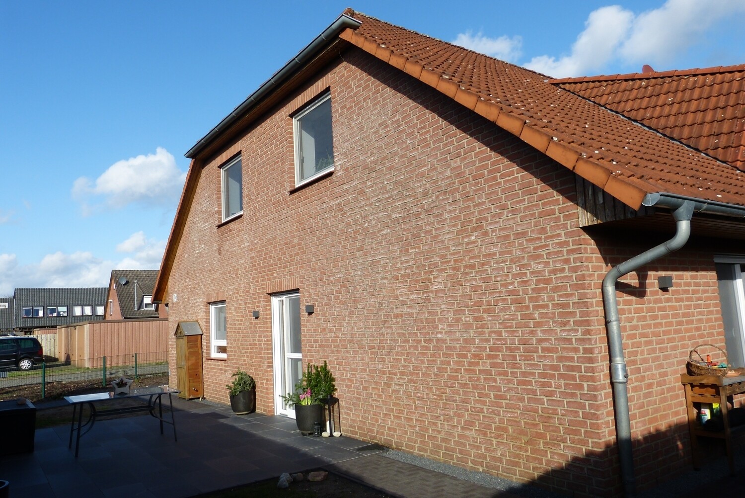 Seitliche Hausfassade mit westlich ausgerichteter Terrasse