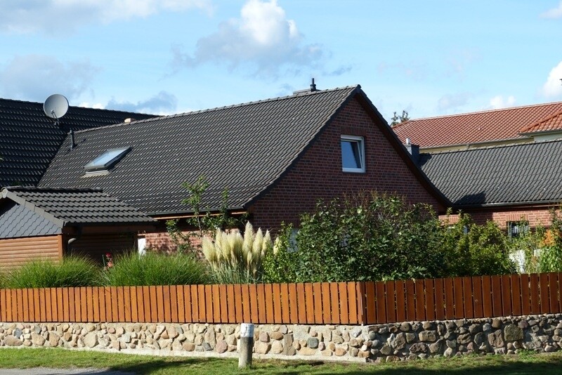 Hausansicht mit Natursteinmauer