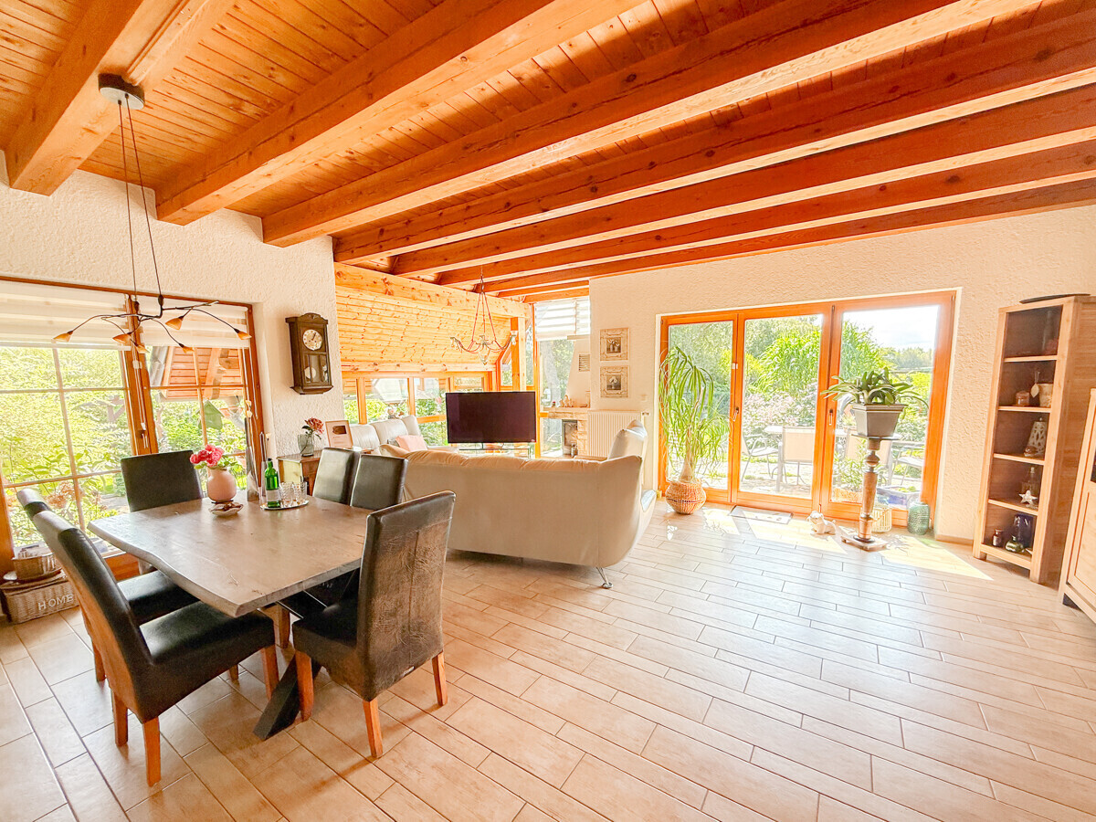 Großer Wohn-Essbereich mit Glasfront und Kamin