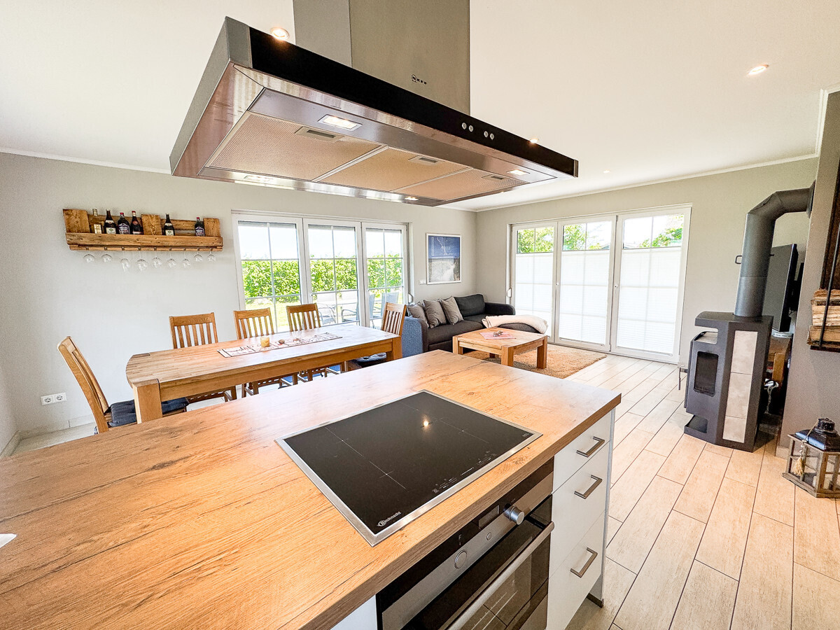 Die moderne Küche mit Insel und Blick in den Wohnbereich