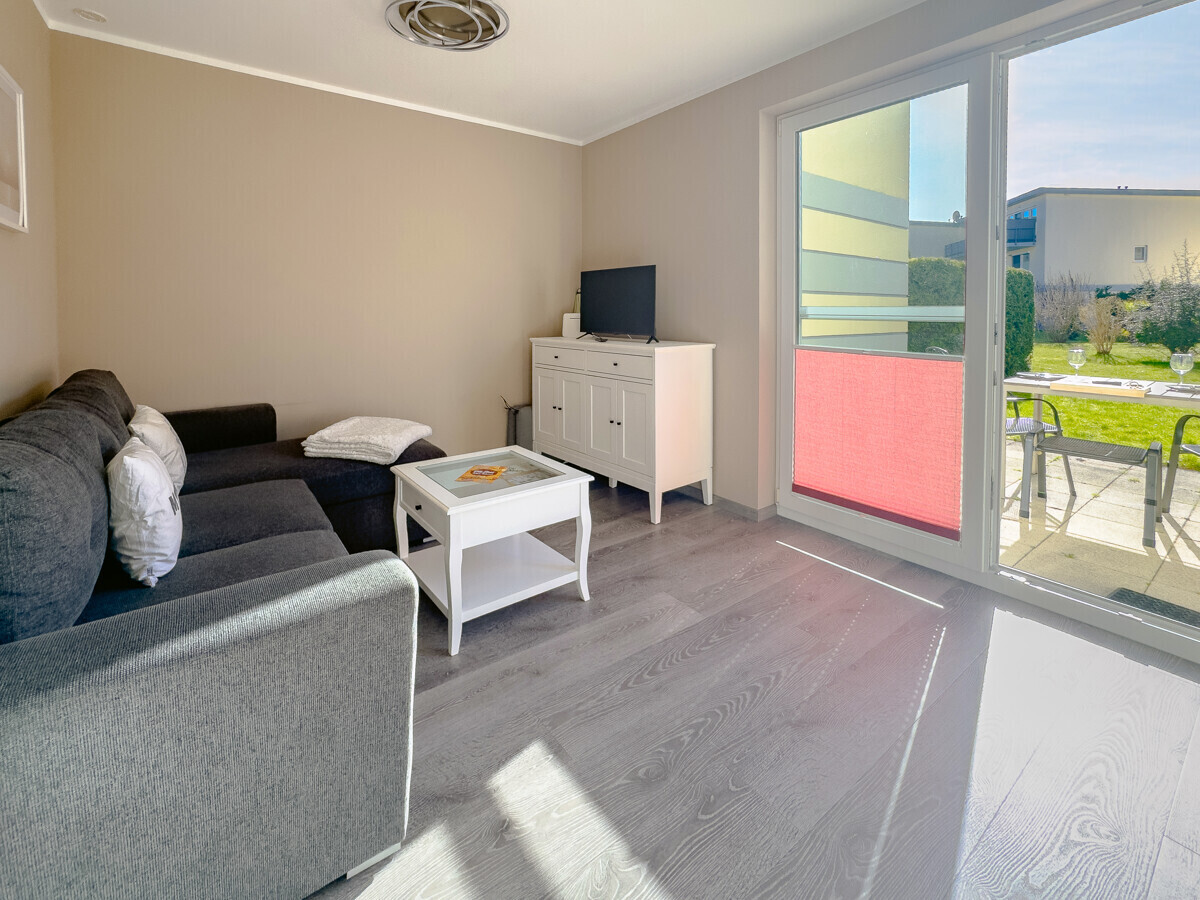 Der helle Wohnraum mit Blick ins Grüne und Zugang zur Terrasse