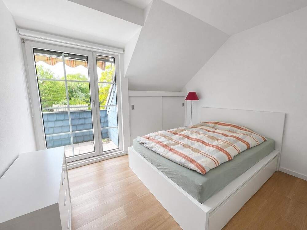 Schlafzimmer mit bodentiefen Fenstern und Zugang zum Balkon