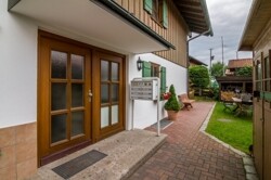 Hauseingang mit Gartenhaus und Holzlege