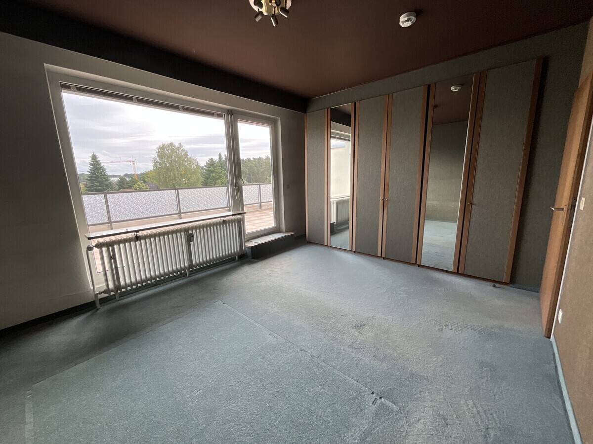 Schlafzimmer mit Einbauschrank und Zugang zur Dachterrasse