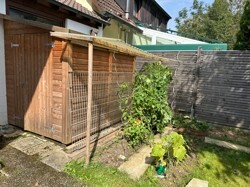 Gartenhäusschen mit Beet hinter Garage