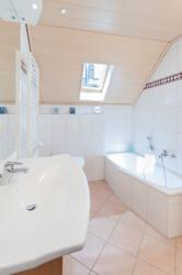 Komfortables Badezimmer mit Badewanne und Dusche