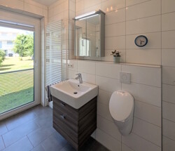 Badezimmer mit Waschbecken und Stehtoilette