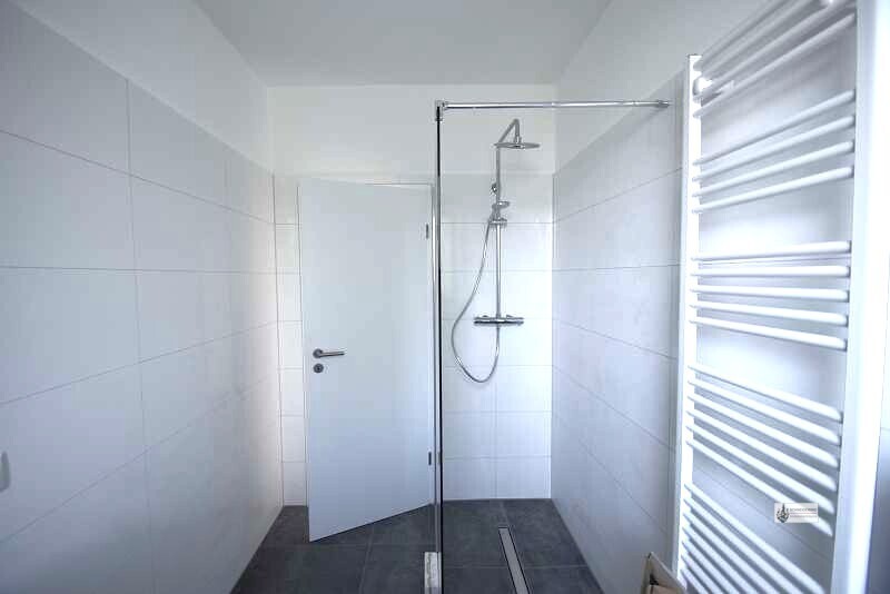 Bad mit Schwalldusche und Glasspritzschutzwand