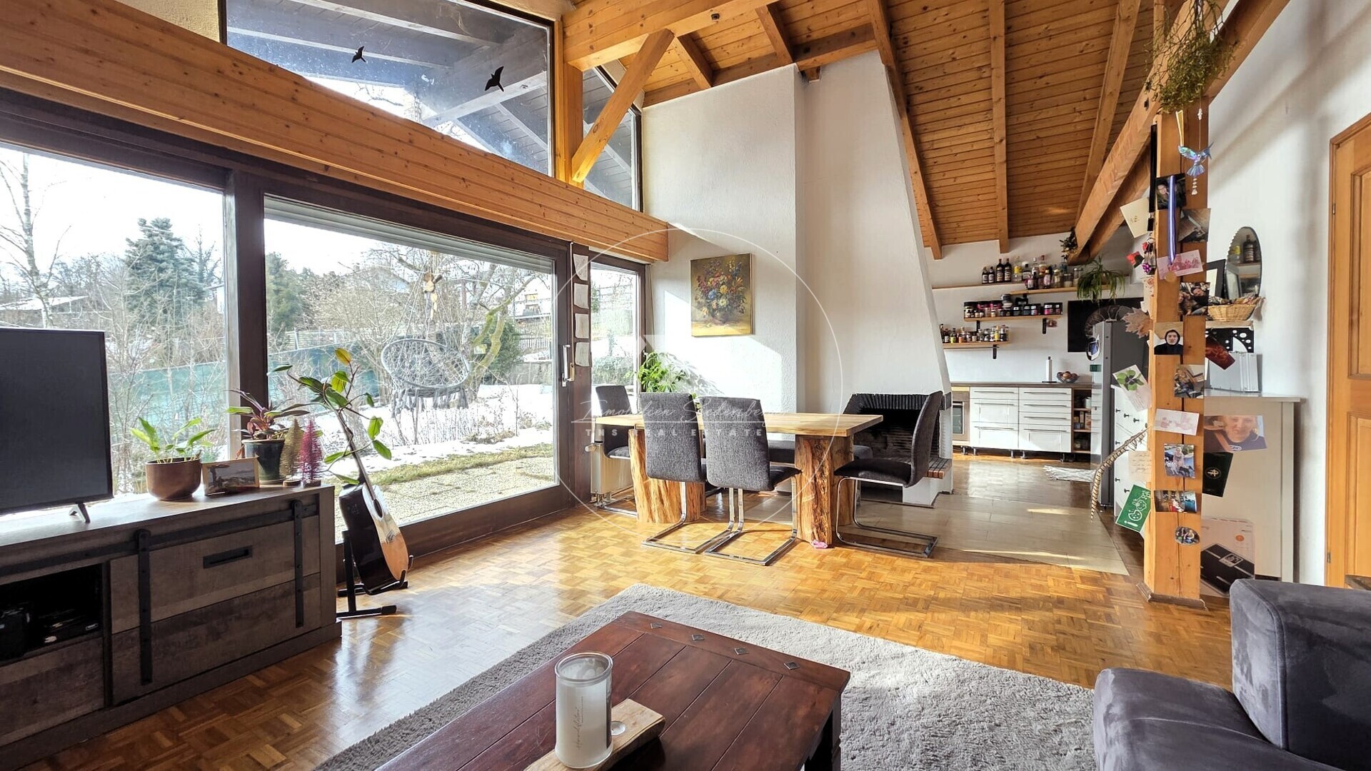 Offener Wohn-Ess-Bereich mit Sichtdachstuhl und Fensterfront