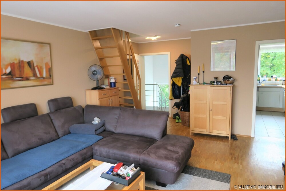 Wohnzimmer mit Blick auf Eingangstür und Küche