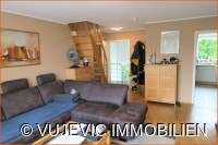 Wohnzimmer mit Blick auf Eingangstür und Küche