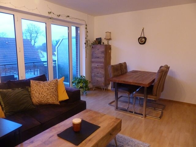 Wohnzimmer mit Essecke und Zugang zum Balkon