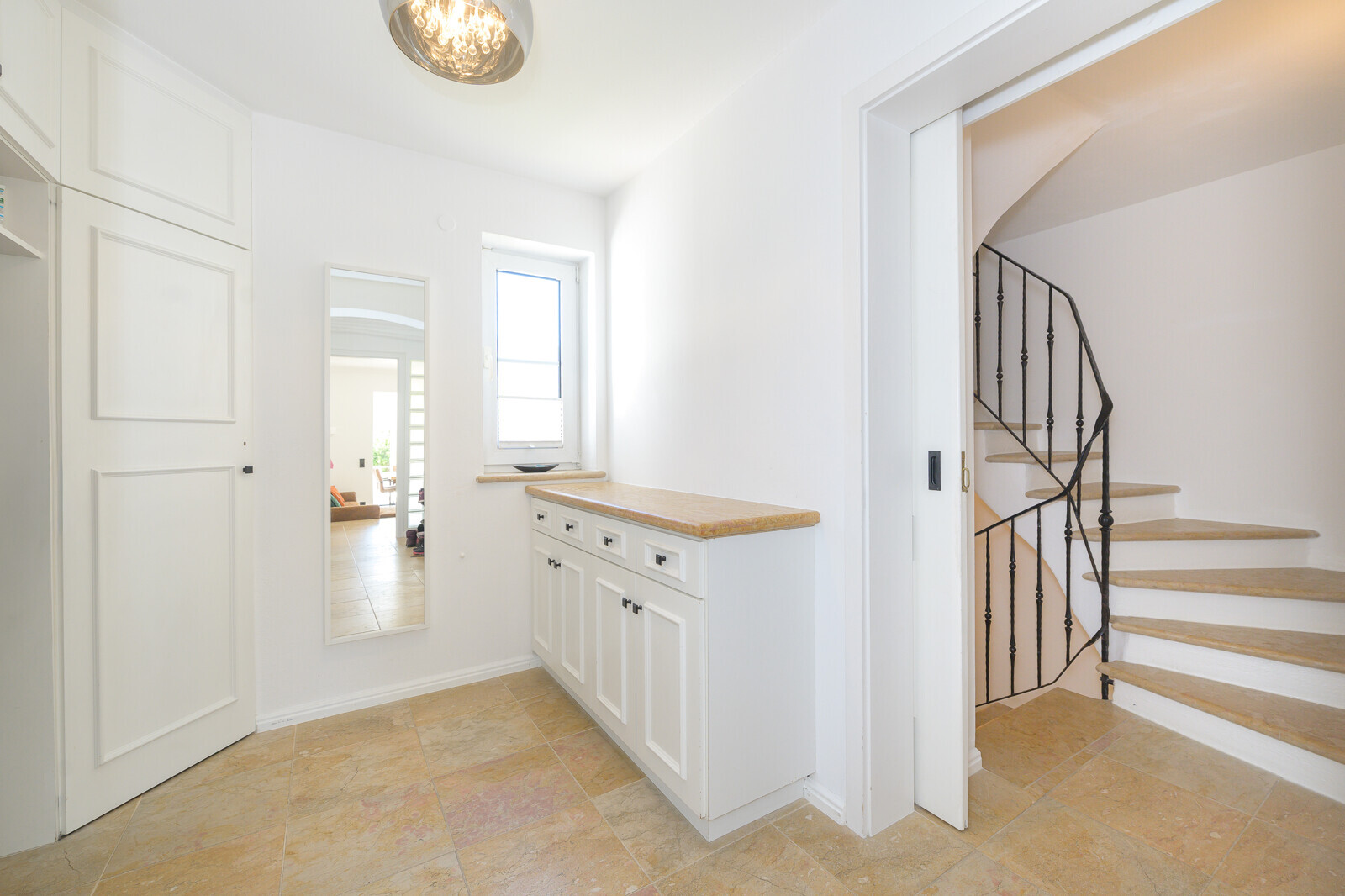 Innenliegende Treppe mit heller Garderobe